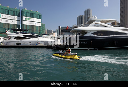 L'uomo su seadoo passando motoryacht di lusso a Aberdeen harbour marina a hong kong RAS di Hong kong cina asia Foto Stock