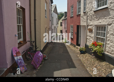 Strada tipica in un Cornish tradizionale villaggio di pescatori. Cawsand, East Cornwall. Bici ragazzi e corpo-boards sinistro esterno. Foto Stock