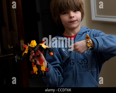 Ragazzo con un mostro di Lego e Star Wars Lego guarda con C3PO sul suo polso Inghilterra Foto Stock