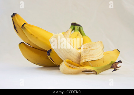 Banane gialle con uno pelato Foto Stock