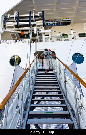 Signora anziana utilizzando la passerella le scale per salire a bordo della nave da crociera MSC Armonia Foto Stock