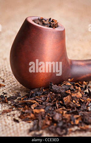 Macro di tubo di fumo e tabacco sulla tela di lino sfondo Foto Stock
