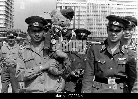 I soldati dell'esercito popolare nazionale con un orsacchiotto in uniforme di Berlino Est. Foto Stock