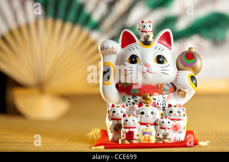 Maneki Neko cat. Comune di scultura giapponese portare buona fortuna al proprietario. Foto Stock