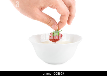 Mano con fragola in crema su bianco Foto Stock