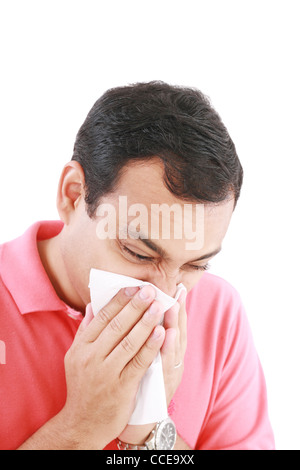 Giovane con un freddo soffia il naso sul tessuto Foto Stock