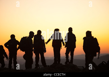 Un gruppo di bambini in età scolare su Orrest testa sopra Windermere al tramonto, nel distretto del lago, UK. Foto Stock