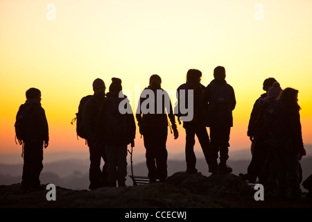 Un gruppo di bambini in età scolare su Orrest testa sopra Windermere al tramonto, nel distretto del lago, UK. Foto Stock