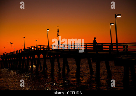 Fisherman su un molo stagliano al tramonto di Sarasota in Florida Foto Stock