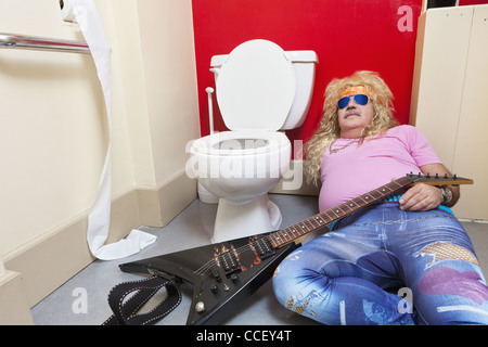 L'Uomo sdraiato in wc con una chitarra Foto Stock