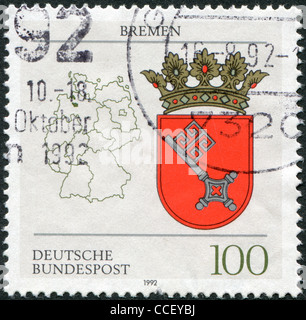 Un timbro stampato in Germania, mostra lo stemma del Land federale di Brema e il tedesco mappa, circa 1992 Foto Stock
