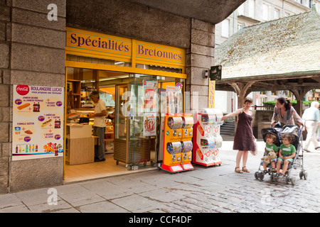 Un negozio nella città vecchia di St Malo vendita specialità bretone. Fuori ci sono alcuni distributori automatici e le persone che vengono sfocatura del movimento Foto Stock