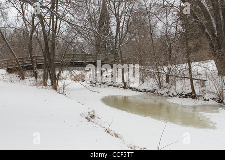 Un piede ponte su un parzialmente congelati creek a Minneapolis, Minnesota. Foto Stock