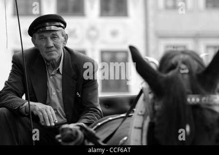 Coachman prende una pausa sigaretta quando si è in attesa per il prossimo i passeggeri in Old Town Market Place, Varsavia, Polonia Foto Stock