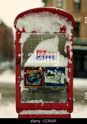21 gennaio 2012: neve visto cadere su di un telefono di emergenza booth nel centro cittadino di New York City, Stati Uniti d'America. Foto Stock