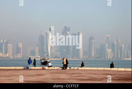 I pescatori di fronte alla Doha skyline del centro, in Qatar Foto Stock