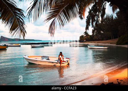 Donna seduta su una piroga in Coin de Mire nel nord dell'Isola di Mauritius Foto Stock