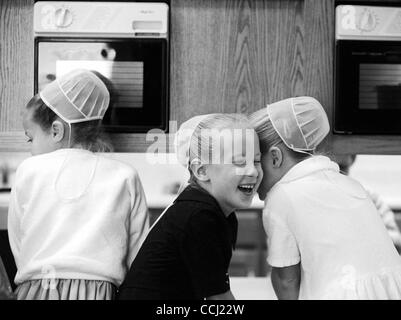 Apr. 11, 2003 - Arthur, Illinois, Stati Uniti - Amish ragazze condividono un segreto in attesa per il loro cibo da riscaldare nel forno a microonde durante il pranzo. Anche se l'elettricità è severamente vietato, setta i bambini non sono date come rigoroso di orientamenti. (Credito Immagine: © Chris Curry/zReportage.com/ZUMA) Foto Stock