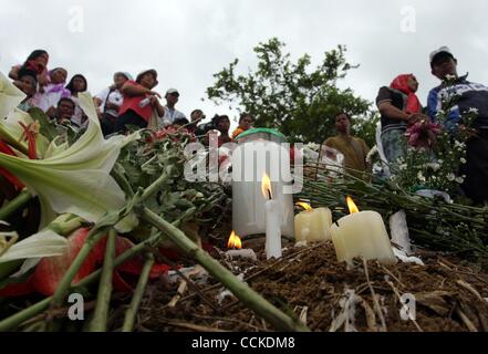 Novembre 23, 2010 - Maguindanao , Filippine - Le famiglie e i parenti, gli amici e i militanti accendono le candele e offrono fiori in corrispondenza del sito nella parte meridionale del paese filippino degli Ampatuan a Maguindanao dove 57 persone sono stati macellati dopo gli ordini di una sentenza clan musulmano. Filippine martedì piangono la uno- Foto Stock