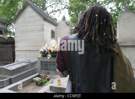 Jul 17, 2004; Paris, Francia; una ventola paga il suo omaggio alla tomba di porte frontman Jim Morrison (1943-1971) @ Pere Lachaise cimitero. Morrison è morto di un attacco di cuore nel 1971 @ l'età di 27. La sua tomba è monitorata dalla polizia 24 ore al giorno ed è spesso barricate per mantenere i fan out. Pere Lachaise è t Foto Stock