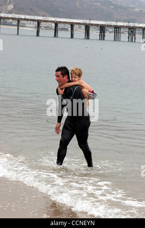 Oct 03, 2004; Malibu, CA, Stati Uniti d'America; ! Chiama per il prezzo! Superdad Dean Cain porta il suo figlio Christopher attraverso il surf in Malibu, California Il Superman star più successivamente ha preso parte al Rip Curl Malibu Pro/Celebrity Surf Bout a beneficio di guarire la baia. Caino ha collaborato con gli attori Mark Ruffalo e Brandon Williams a b Foto Stock