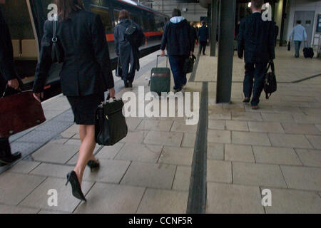 Oct 05, 2004; Leeds, Regno Unito; viaggiatori e passeggeri presso la stazione ferroviaria di Leeds. I viaggiatori di affari in abito scuro con brevi casi fretta in tutta la piattaforma. I mezzi di trasporto pubblico nel Regno Unito è invocata da milioni. Londra il sistema di trasporto e la British Rail Pendolari consentono di raggiungere il posto di lavoro di tutti i giorni. Foto Stock