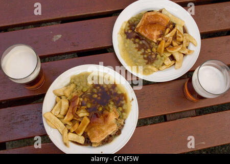 Oct 05, 2004; Leeds, Regno Unito; reale British pub grub in un giardino della birra a Leeds. Chip grafico a torta e cedevole i piselli o fave con una pinta di birra sono pranzo tradizionale in Inghilterra. La promozione di grassi, zuccherino e generalmente cibo malsano rivolte ai bambini nel Regno Unito ha cause i giovani ad essere malsana studi mostrano come Ca bassa Foto Stock