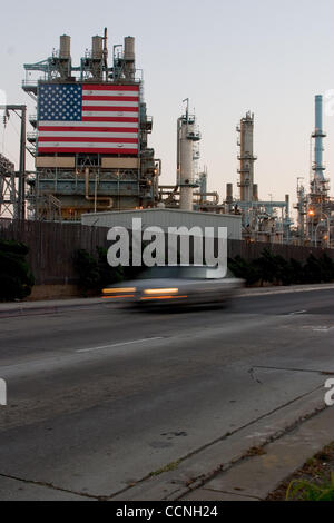 Oct 18, 2004; Long Beach, CA, Stati Uniti d'America; la Conoco philips raffineria di petrolio a Carson nr Long Beach in California con grandi stelle e strisce di bandiera degli Stati Uniti appeso accanto alla enorme chimmney fumaioli. La raffineria ha recinto di sicurezza con filo spinato filo spinato intorno ad esso. La sicurezza è stata aumentata a refinerys attraverso Foto Stock