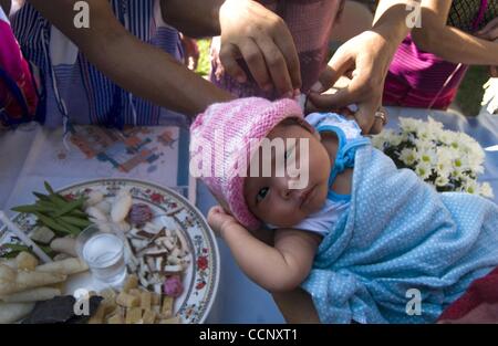 Feb 21, 2004 - Houston, Texas, Stati Uniti - Un bambino subisce una parte di una celebrazione in onore della vendemmia a Sun Blossom appartamenti. Più di 100 famiglie birmane vivono ora a Sole fiore di montagna e il suo complesso gemellato attraversata la strada. Una nuova famiglia sembra apparire ogni settimana. Essi stanno entrando cos refug Foto Stock