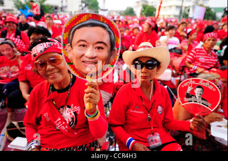 Una maglietta rossa sostenitori dell ex primo ministro tailandese Thaksin Shinawatra attribuisce la maschera di Thaksin Shinawatra ha la sua ventola. Le Camicie Rosse si raccoglie da tutto il paese, chiedendo il Primo Ministro Abhisit Vejjajiva per una dissoluzione della casa e la chiamata per una nuova elezione. Foto Stock