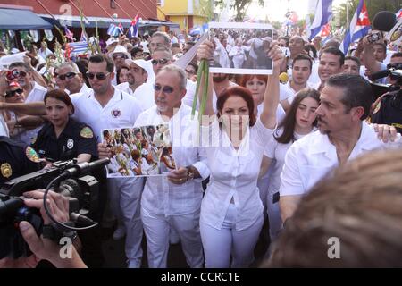 Mar 26, 2010 - Miami, Florida, Stati Uniti d'America - cantante GLORIA ESTEFAN detiene una fotografia di Cuba il Las Damas de Blanco, Donne in bianco, come ella marche in loro favore in Little Havana. A Cuba la settimana scorsa, le donne in bianco sono stati attaccati dalle forze di sicurezza governative durante una tranquilla marzo a l'Avana. (Cre Foto Stock