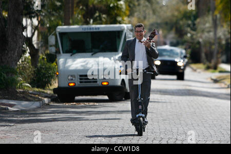 DIRK SHADD | Orari SP 319640 SHAD FEATURE 01 (03/02/10 ST. PETE) Steaven Harbin (CQ) lancia il suo tirante sulla sua spalla come egli commuta a casa dal lavoro sulla sua Schwinn scooter elettrico mentre in direzione nord sulla Quinta Strada Uptown/intorno al lago di quartiere di San Pietroburgo Mercoledì pomeriggio (03 Foto Stock