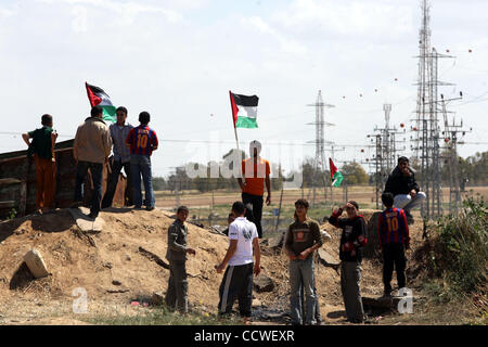 Mar 30, 2010 - Nahal Oz Crossing, Gaza City - un manifestante mette su una bandiera palestinese durante una manifestazione di protesta per la marcatura giorno terra vicino il Nahal Oz attraversamento est di Gaza City sulla frontiera di Israele. Il 30 marzo la marchi terra annuale Giorno commemora l uccisione di sei palestinesi nel 1976 quando le forze israeliane hanno disperso un Foto Stock