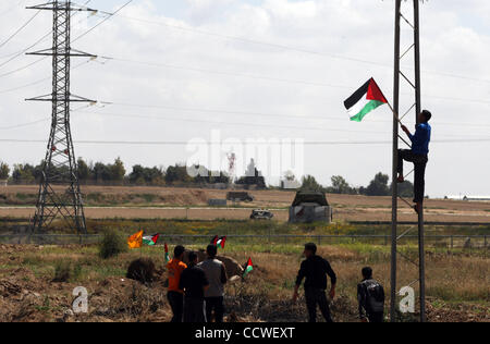 Mar 30, 2010 - Nahal Oz Crossing, Gaza City - un manifestante mette su una bandiera palestinese durante una manifestazione di protesta per la marcatura giorno terra vicino il Nahal Oz attraversamento est di Gaza City sulla frontiera di Israele. Il 30 marzo la marchi terra annuale Giorno commemora l uccisione di sei palestinesi nel 1976 quando le forze israeliane hanno disperso un Foto Stock