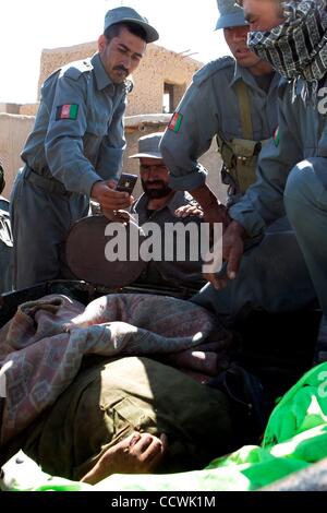 17 maggio 2010 - Provincia di Herat, Afghanistan - Polizia nazionale afgana scatta foto del cadavere di un sospetto di talebani combattente che è stato ucciso durante un combattimento che ha lasciato due U.S. Veicoli militari disabili, nella provincia di Herat. Stati Uniti I soldati dell esercito da Alfa truppa, 4° Stormo, 73rd reggimento di cavalleria, 4 BRI Foto Stock