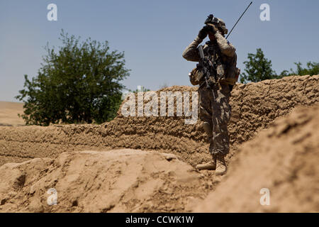 18 maggio 2010 - Provincia di Herat, Afghanistan - STATI UNITI Army Sgt. Joshua Hampson della sede centrale e sede Battery Company, 2° Battaglione, campo 321artiglieria, quarta brigata Team di combattimento, ottantaduesima Airborne Division, orologi per un movimento mentre il pattugliamento un villaggio nel distretto di Kushk della provincia di Herat, Foto Stock