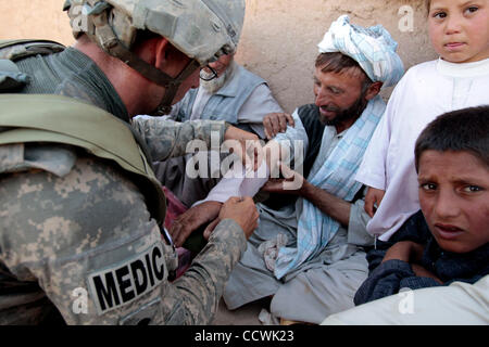 18 maggio 2010 - Provincia di Herat, Afghanistan - STATI UNITI Army Spc. Bradley Oliff, quartier generale della società, Alfa truppa, 4° Stormo, 73rd reggimento di cavalleria, quarta brigata Team di combattimento, ottantaduesima Airborne Division, considera un abitante di un villaggio che ha sofferto un braccio rotto in un villaggio nel distretto di Kushk della provincia di Herat, Afgh Foto Stock