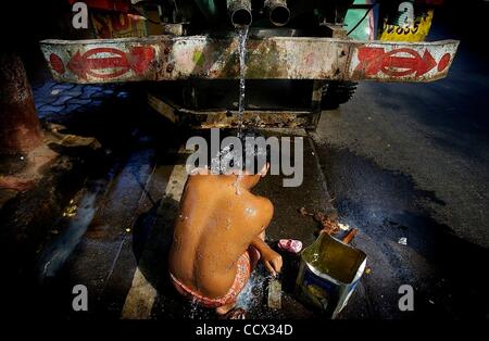 Apr 22, 2010 - Mumbai, Maharashtra, India - un giovane uomo si accovaccia sotto l'acqua da un carrello. (Credito Immagine: Â© Michael Francis McElroy/ZUMA Press) Foto Stock