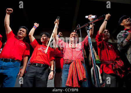 Apr 04, 2010 - Bangkok, Thailandia - Leader della maglietta rossa VEERA MUSIGAPONG (C) e il ben wishers delle camicie rosse tifo durante il governo anti le dimostrazioni presso il quartiere commerciale downtown Bangkok il 04 aprile 2010. Migliaia di maglietta rossa sostenitori dell ex PM Thaksin Shinawatra de Foto Stock