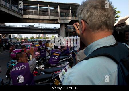 Apr 20, 2010 - Bangkok, Tailandia - un turista straniero è visto scattare foto di scena dove le forze di sicurezza e la maglietta rossa dimostranti sono edificazione le forze. La tensione si accumula come il governo tailandese ha distribuito i soldati dell esercito e della polizia a guardia del quartiere finanziario. Camicie Rosse hanno b Foto Stock