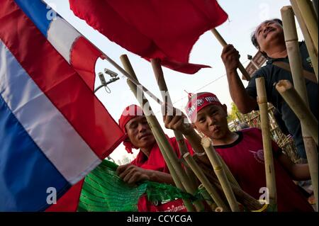 Apr 20, 2010 - Bangkok, Thailandia - Anti governo manifestanti, tra i quali un bambino, wave UDD bandiere mentre gridando slogan contro il governo a eretto delle barricate sulla 'separazione' di linea tra esercito thailandese e dimostranti nel quartiere finanziario di Bangkok. La tensione si accumula come il Thai governme Foto Stock