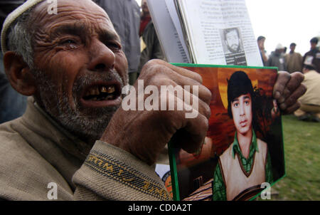 Il padre di un mancante della gioventù del Kashmir grida come i parenti dei giovani del Kashmir che sono scomparsi sedetevi tenendo cartelloni durante la manifestazione a Srinagar, la capitale estiva del Kashmir indiano, 10 aprile 2008. Associazione dei Genitori di Persone scomparse (APDP) ha organizzato una manifestazione di protesta contro il Foto Stock