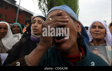 La madre di un mancante della gioventù del Kashmir grida come i parenti dei giovani del Kashmir che sono scomparsi sedetevi tenendo cartelloni durante la manifestazione a Srinagar, la capitale estiva del Kashmir indiano, 10 aprile 2008. Associazione dei Genitori di Persone scomparse (APDP) ha organizzato una manifestazione di protesta contro il Foto Stock