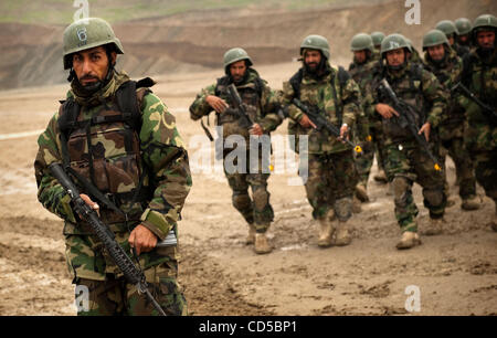 Apr 09, 2008 - Camp Morehead, Afghanistan - Afghanistan Commandos marzo attraverso un campo fangoso per arrivare alla loro Humvees convoglio per la formazione sotto la supervisione degli STATI UNITI Esercito forze speciali militari. Creato due anni fa da noi le forze speciali, i commandos sono aumentati dall'esercito nazionale afghano di eli Foto Stock