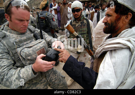 08 apr 2008 - Provincia di Paktya, Afghanistan - il rilevamento delle impronte digitali di un sospetto di commerciante di armi nelle zone rurali Afghanistan orientale, Staff Sergente Jake Schlereth utilizza un dispositivo di campo che registra anche la retina scansioni e informazioni biografiche. Schlereth è un leader di squadra di Charlie Company, 1-61 Cavalleria, quarta brigata Foto Stock