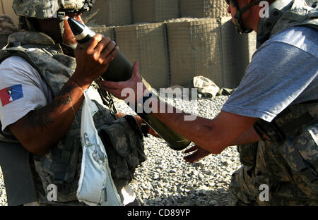 Oct 10, 2008 - Paktya, Afghanistan - il sergente QUENTIN GARY passa un 105mm rotondo di artiglieria a uno specialista del caricatore GEORGE MORRIS durante un contatore di artiglieria-shoot in risposta ad un mortaio dei talebani e attacco a razzo sul combattimento avamposto deserto, Paktya provincia, in Afghanistan, in cui gli equipaggi della Fie 4-320 Foto Stock