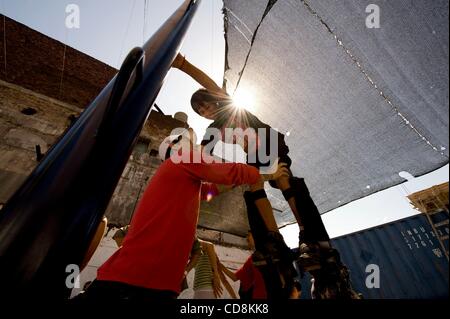 20 nov 2008 - Buenos Aires, Argentina - PEDRO 'Peligroso' Palacios, sinistra, aiuta a PAULO MARTINEZ, 14, salire su una coppia di palafitte era il Grupo de Teatro Catalinas Sur, un gruppo di teatro di strada, dà un workshop per i residenti del quartiere La Boca a Buenos Aires, Argentina. (Credito Immagine: © Calt Foto Stock