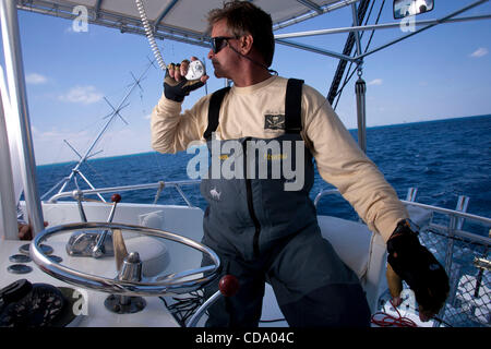 Luglio 28, 2010 - Miami, Florida, USA - Capitano ''Marca Lo Squalo'' QUARTIANO, di Pompano Beach, FL, parla con un altra barca durante la ricerca per il suo preferito luogo di pesca lungo la curva della corrente del Golfo, a circa 2 miglia al largo della costa di Miami, Florida. QUARTIANO è rinomata in tutto il mondo come il cacciatore di squali basato o Foto Stock