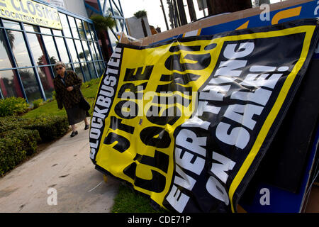 Apr. 12, 2011 - Hollywood, California, Stati Uniti - una donna cammina davanti a un chiuso recentemente Blockbuster Video Store a Hollywood. La scorsa settimana, la rete del piatto è stato il miglior offerente in tribunale fallimentare asta per il blockbuster di risorse video. Piatto dice che intende pagare circa 230 milioni di dollari in contanti e e Foto Stock