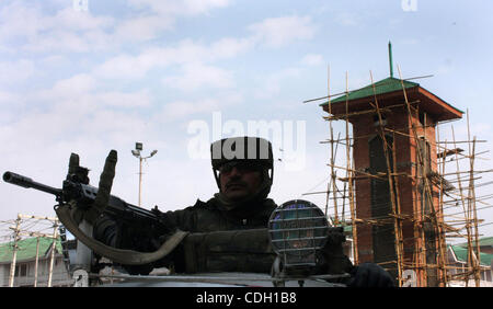 Jan 25, 2011 - Srinagar Kashmir, India - un poliziotto indiano sta di guardia nella parte anteriore del Kashmir la torre dell orologio nello storico Lal Chowk (quadrato rosso) area davanti di un progetto di bandiera nazionale il sollevamento da India del principale partito d opposizione Bharatiya Janata Party (BJP) presso la torre sul giorno della Repubblica, a Srinagar, l'estate c Foto Stock